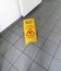 A sign showing a warning about wet floors in Russian and English