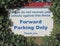 A sign in a Sidmouth car park giving parking instructions. Ivy has been cut away to stop it being obscured