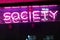 Sign society word neon sign. pink light. glass showcases