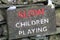 Sign stating SLOW CHILDREN PLAYING