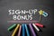 Sign-up bonus. Text on a dark chalk board