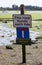 A sign warning against car parking on a road that floods with each high tide