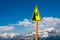 A sign warning about the danger of falling into the abyss against the background of high snow-covered mountain peaks