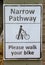 Sign warning of narrow pathway and to please walk your bike