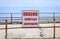 A sign with the words Dangerous Swimming Prohibited on rusty handrails on an abandoned embankment.