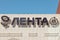 Signboard, name of store logo Lenta on building of Planet shopping center. Inscription on wall - Ribbon