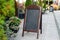 Signboard on the street. Empty menu board stand. Restaurant sidewalk chalkboard sign board. Freestanding A-frame blackboard near