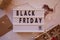 Signboard with text Black Friday and decorations. Online shopping concept. Buying presents for Christmas. Safe home