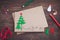 Signing handmade Christmas card with felt Christmas-tree, snowflakes effect and red star