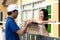 Signing to get her package. Delivery man holding a cardboard box woman putting signature in clipboard for shopping online.