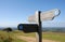 A signpost and a couple walking on the South Downs Way near Brighton in Sussex, England, UK