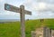 A signpost shows the route of the South Downs Way with two unrecognizable hikers