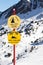 Signs in the mountains at a ski resort with hazard warnings.