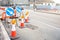 Signs and traffic cones at the beginning of a construction site along a wide urban road