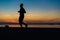 Sihouette of Young Man Running by the Sea, against beautiful aft