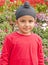 A Sikh boy standing ahead of flowers