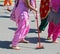 Sikh woman walking barefoot cleans the street with a broom