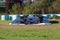 Silage pile of fermented high moisture stored fodder covered with thick nylon and used car tyres with hay bales wrapped in plastic