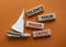 Silence your inner critic symbol. Wooden blocks with words Silence your inner critic. Beautiful orange background with boat.