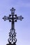 silhouete of a decrative, iron cross, on top of, a christian gravestone