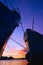 Silhouette 2 oil tankers moored at port with many vessels in riverbank area against colorful twilight sky background