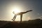 Silhouette of acrobatic teen gymnast balancing with the sun behind