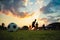 Silhouette action sport outdoors of a group of kids having fun playing soccer football for exercise in community rural area under