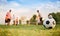 Silhouette action sport outdoors of a group of kids having fun playing soccer football for exercise in community under