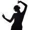 Silhouette of a active girl listening to music in headphones, figure of young woman dancing with hands up on a white isolated
