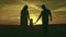 silhouette affectionate parents with child sunset. happy african family sunset park. mother father hold kid hands