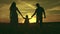 silhouette affectionate parents with child sunset. happy african family sunset park. mother father hold kid hands