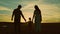 silhouette affectionate parents with child sunset. happy african family sunset park. mother father hold kid hands