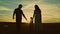 silhouette affectionate parents with child sunset. happy african family sunset park. mother father hold kid hands