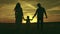 silhouette affectionate parents with child sunset. happy african family sunset park. mother father hold kid hands