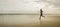 Silhouette of African American woman running on the beach - young attractive and athletic black girl training outdoors doing