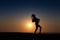 Silhouette of African girl on hill top posing and dancing with sunset view and ocean view.