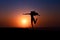 Silhouette of African girl on hill top posing and dancing with sunset view and ocean view.