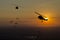 Silhouette airplane,helicopter and parachute at sunset.