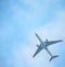 Silhouette of an airplane on sky background. Commercial airplane jetliner flying above clouds in beautiful day light. Flight trave