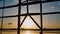 Silhouette of an airplane taking off at sunset at Beijing airport in the background of a window.