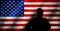 Silhouette of an American soldier in military beret facing grunge style USA national flag