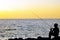 Silhouette of angler fishing on the rock at the beach of malacca