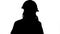 Silhouette Angry woman construction worker in a hardhat shouting, talking on smartphone.