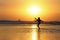 Silhouette of anonymous unknown young kid having fun playing on sea water at the beach kicking on wet sand with amazing beautiful