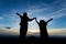 Silhouette of asian child girl and her mother raise their arms looking at the beautiful mist and mountain together at sunset time