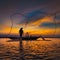 Silhouette of asian fisherman on wooden boat in action