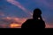 Silhouette of asian man stay alone with dusk sky background.