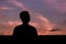 Silhouette of asian man stay alone with dusk sky background.