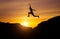 Silhouette of athlete, jumping over rocks in mountain area