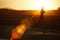 Silhouette of athletic girl running along the beach on amazing orange sunset background